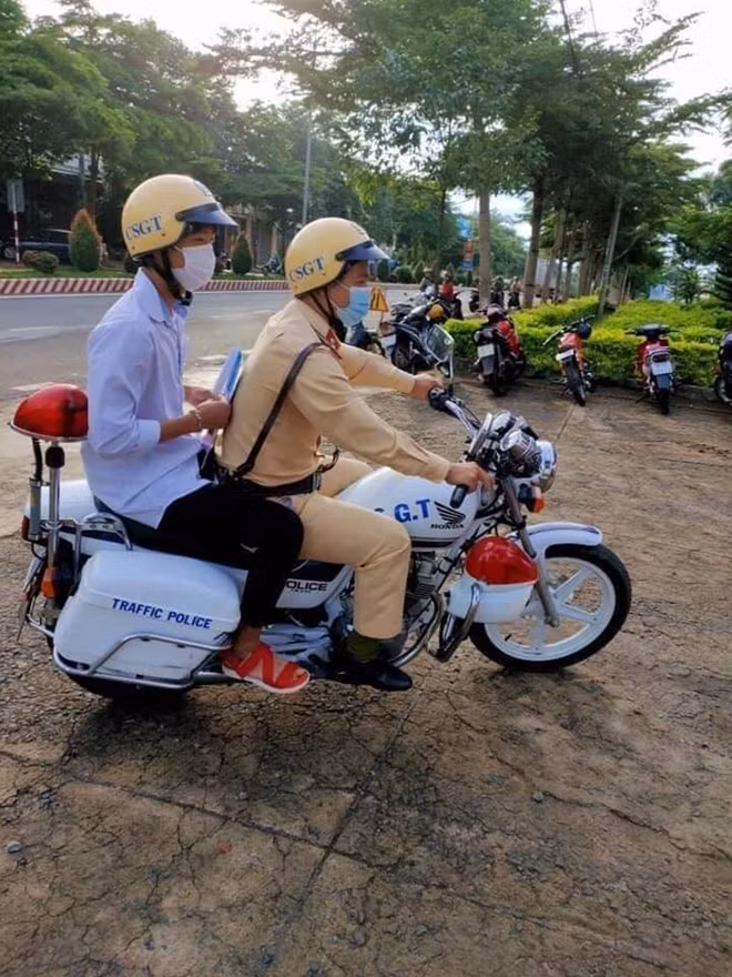 Cán bộ Đội CSGT huyện Đắk Mil giúp thí sinh đi mua Atlat địa lý để kịp giờ vào phòng thi
