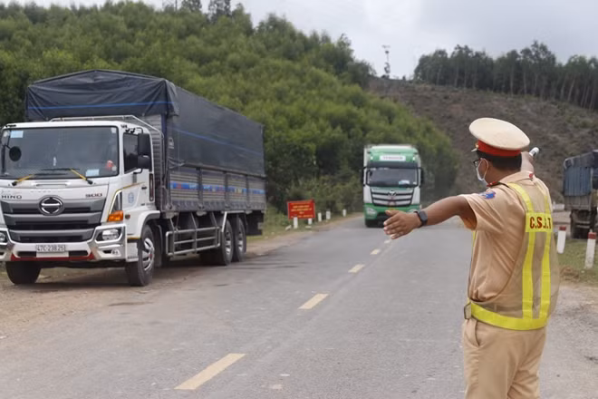 Lực lượng CSGT phân luồng giao thông tại chốt kiểm dịch trên QL26