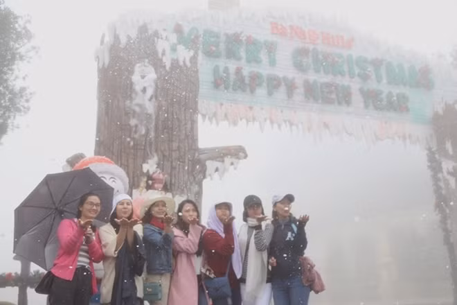 Nhiều bạn trẻ thích thú lưu lại những hình ảnh đẹp ngay cổng chào với những bông tuyết bay trắng trời…