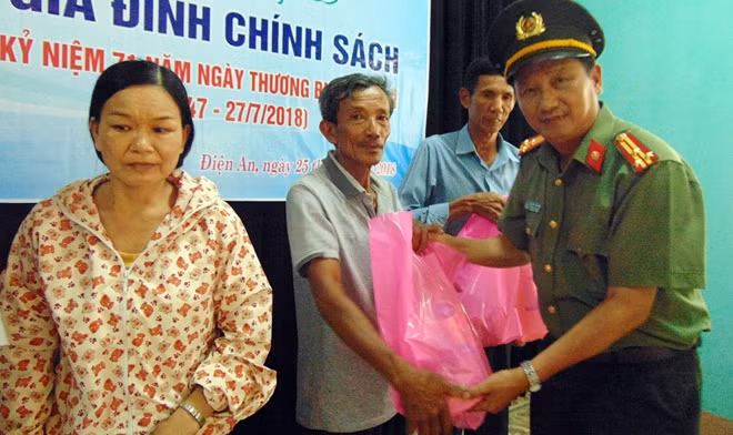 Thượng tá Nguyễn Văn Long, Phó Trưởng Ban Thư ký tòa soạn, Trưởng Văn phòng Thường trú miền Trung Báo CAND, trao quà cho các gia đình chính sách tại phường Điện An, thị xã Điện Bàn.