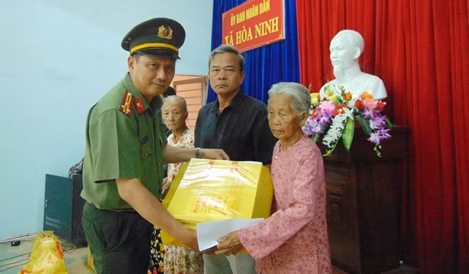 Đại diện Báo CAND, Thượng tá Nguyễn Văn Long, Phó Trưởng ban Thư ký Tòa soạn, Trưởng Văn phòng Thường trú miền Trung, trao quà cho các hộ dân.