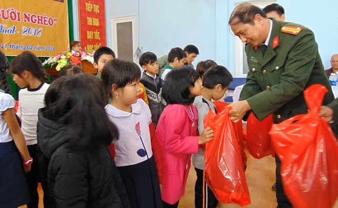 Đại diện Báo CAND trao quà cho các em học sinh.