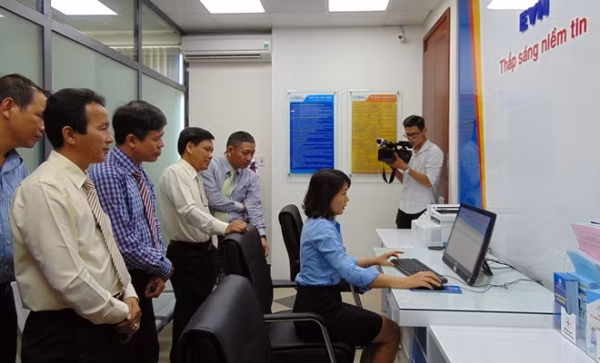 Nhân viên điện lực hướng dẫn làm thủ tục tại quầy dịch vụ điện trực tuyến.