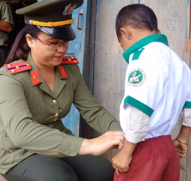 Nữ đoàn viên Công an mặc áo quần mới tặng các em học sinh.