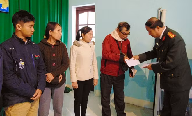 Trung tá Nguyễn Văn Long, Phó Trưởng ban Thư ký Tòa soạn, Trưởng Văn phòng Thường trú miền Trung Báo CAND, trao quà cho bà con.