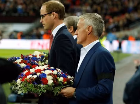 Hoàng tử Anh William và HLV trưởng của ĐT Pháp Didier Deschamps với vòng hoa tưởng nhớ các nạn nhân đã thiệt mạng.
