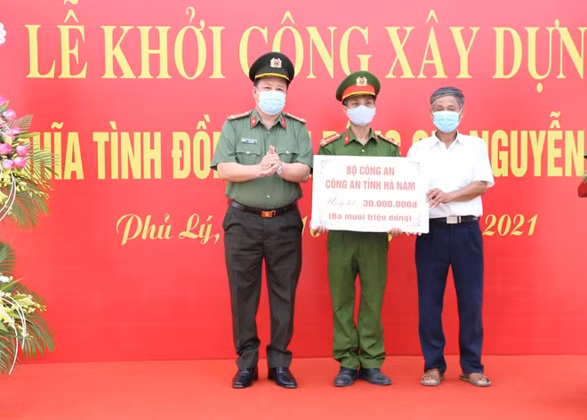 Đại tá Nguyễn Quốc Hùng, Giám đốc Công an tỉnh trao kinh phí hỗ trợ của Bộ Công an, Công an tỉnh cho gia đình Đại úy Nguyễn Văn Hiệu.