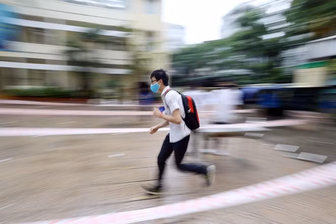 Một thí sinh đến muộn, gần sát giờ thi vội vã chạy nhanh vào làm thủ tục.