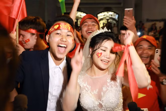 Đôi bạn trẻ đã có một kỷ niệm đáng nhớ khi thực hiện bộ ảnh cưới của mình trong ngày tuyển Việt Nam chiến thắng, giữa tiếng reo hồ ăn mừng của hàng nghìn người hâm mộ bóng đá.