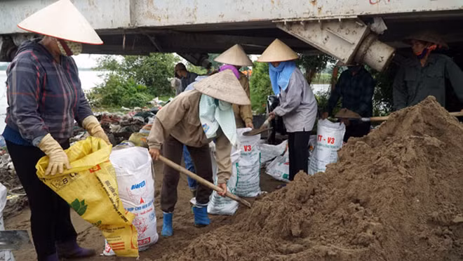 Trước tình hình trên, trong sáng 30-7, hàng trăm người dân tại xã Thanh Bình đã được huy động phối hợp với bộ đội tham gia đắp bao cát ngăn nước tràn qua đê. Trước tình hình trên, trong sáng 30-7, hàng trăm người dân tại xã Thanh Bình đã được huy động phối hợp với bộ đội tham gia đắp bao cát ngăn nước tràn qua đê.