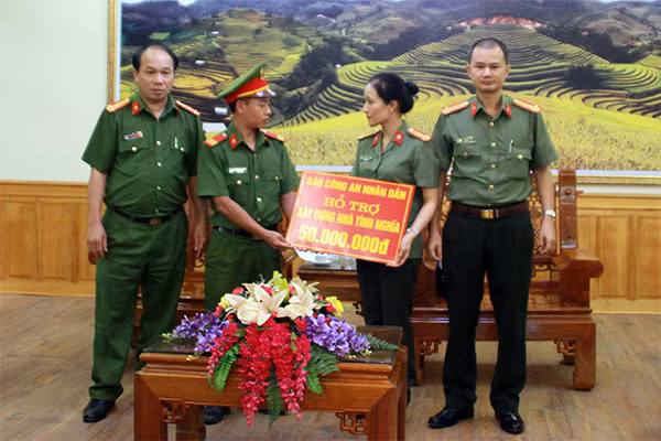 Thượng tá Nguyễn Thúy Quỳnh, Phó Tổng Biên tập Báo CAND trao số tiền 50 triệu đồng cho đồng chí Thào A Giao