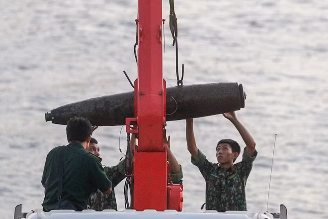 Quả bom có chiều dài 1,6m, đường kính khoảng 35cm, nặng gần 280 kg được kéo lên.