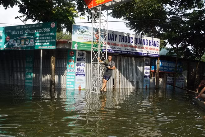 Phóng viên Phong Sơn (Báo CAND) đang tìm cho mình một điểm cao giữa vùng ngập để ghi lại góc nhìn mới cho tác phẩm của mình.