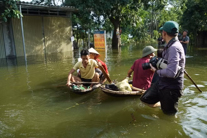 Trong khi người dân di chuyển trong vùng ngập hầu hết đều bằng phương tiện thuyền cá nhân thì riêng với phóng viên, việc lội nước lại là điều rất bình thường.