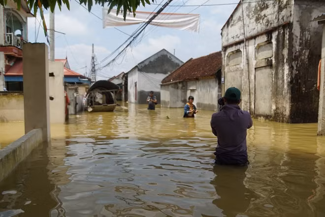 Phóng viên Báo CAND ngâm mình tác nghiệp tại vùng ngập Chương Mỹ. Việc tác nghiệp rất khó khăn bởi ngập nước, đi lại phải hết sức cẩn thận không sẽ bị rơi xuống hố sâu. Ướt người không quan trọng mà phải cẩn trọng với đồ nghề, phương tiện. Những chiếc máy ảnh, máy quay trị giá mấy chục triệu, thậm chí có chiếc hơn 100 triệu đồng. Rơi xuống nước thì "tan" sự nghiệp!