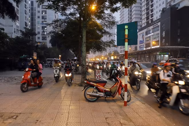 Chờ đợi đôi khi không phải lúc nào cũng là "hạnh phúc", nhiều người đi xe máy đã chọn cách lao lên vỉa hè để tìm đường về nhà.