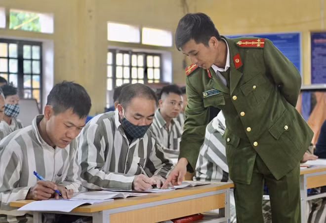 Đại úy Lê Quyết Thắng - cán bộ Đội Giáo dục đang giảng bài trong lớp học xóa mù chữ ở Trại giam Hồng Ca