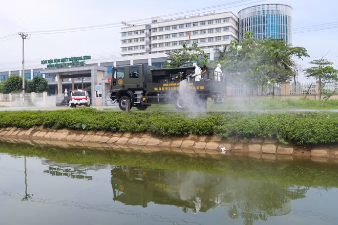 Bộ đội Hóa học bắt đầu phun thuốc khử khuẩn từ phía bên ngoài, cách bệnh viện 100m sau đó di chuyển dần vào trong khuôn viên bệnh viện trước khi phân tổ nhóm phun thuốc theo từng khu vực được giao nhiệm vụ.