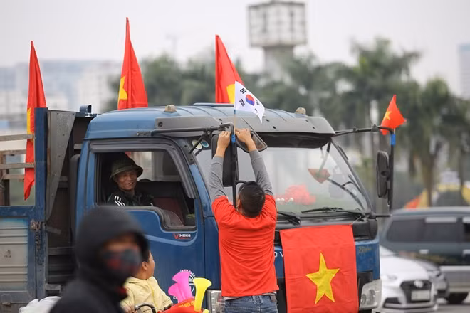 Việc trang trí cổ vũ đội tuyển Việt Nam có thể được bắt gặp ở bất cứ nơi đâu. Một CĐV đang tranh thủ trang trí cờ Việt Nam cùng với lá quốc kỳ Hàn Quốc như muốn bày tỏ sự cảm ơn giành cho HLV Park Hang-seo.