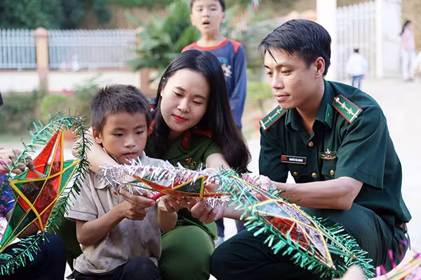 Cán bộ, đoàn viên hai đơn vị tận tình hướng dẫn các em nhỏ làm đèn ông sao chuẩn bị cho Đêm hội trăng rằm