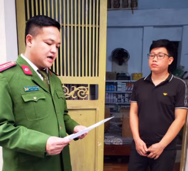 Công an đọc lệnh khám xét.