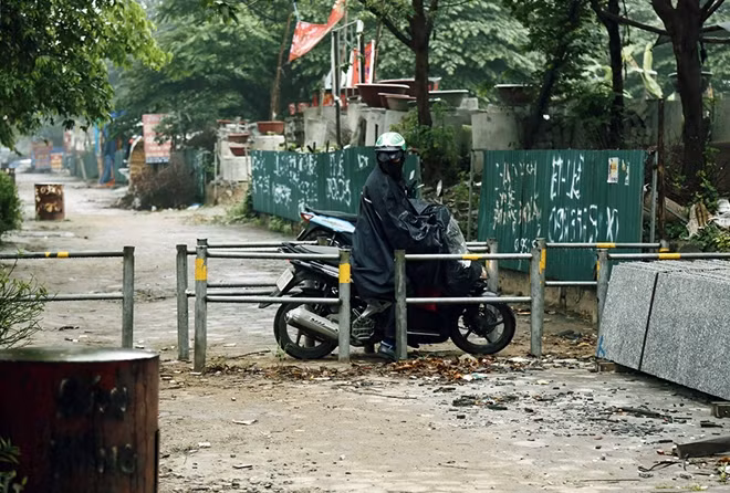 Một người đi xe máy vì sợ bị CSGT xử phạt lỗi đi ngược chiều lên "quyết tâm" luồn lách qua hàng rào trên vỉa hè để di chuyển.