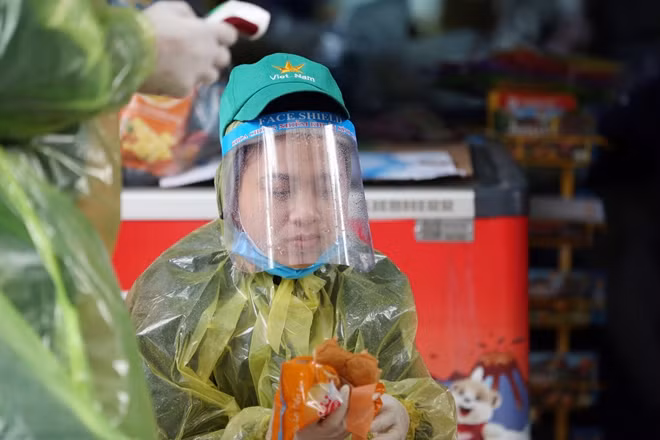 Ngồi nép bên mái hiên nhà ở khu vực chốt kiểm tra, chị Dương Thị Hồng ăn vội chiếc bánh mỳ cho bữa sáng để tiếp tục làm nhiệm vụ.