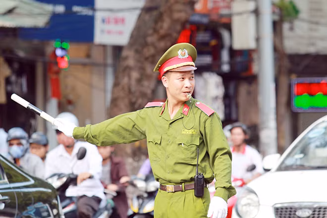 Một học viên Cảnh sát được tăng cường giúp lực lượng CSGT điều tiết giao thông.