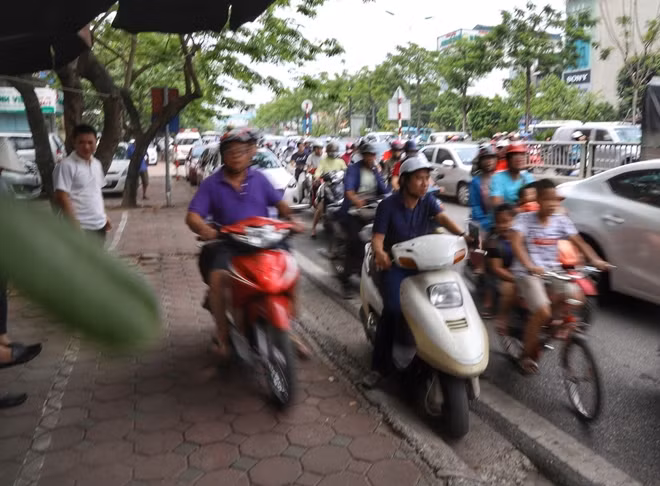 Nhiều người đi xe máy lao luôn lên vỉa hè để vượt qua đoạn đường đang bị ùn tắc.