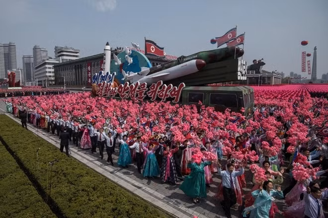 Người dân diễu hành cùng mô hình tên lửa. Ảnh: AFP