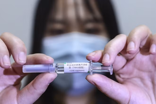 Nhân viên Tập đoàn dược quốc gia Trung Quốc (Sinopharm) giới thiệu mẫu vaccine phòng dịch COVID-19 tại nhà máy của Tập đoàn ở Bắc Kinh.