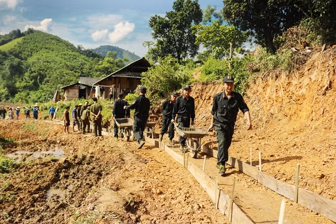 Cán bộ chiến sĩ Cảnh sát cơ động xuống các làng, bản giúp đỡ nhân dân làm đường.