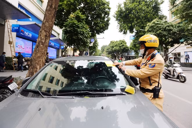 Lực lượng CSGT Hà Nội dán thông báo "phạt nguội" ô tô vi phạm dừng, đỗ.