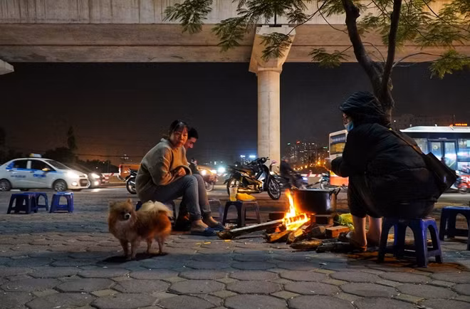 Càng về tối, trời càng lạnh hơn, những đống lửa trở thành điểm đến của nhiều người dân để chống rét. Hình ảnh ghi lại trên đường Hồ Tùng Mậu.