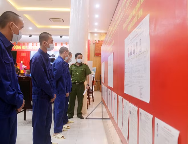 Những cử tri "đặc biệt" của Trại tạm giam số 1 xem lại danh sách ứng cử viên trước khi bầu.