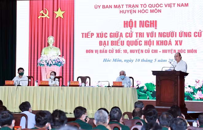 Chủ tịch nước Nguyễn Xuân Phúc (ảnh trái) và Chủ tịch Quốc hội Vương Đình Huệ trình bày chương trình hành động tại buổi tiếp xúc cử tri. Ảnh: TTXVN