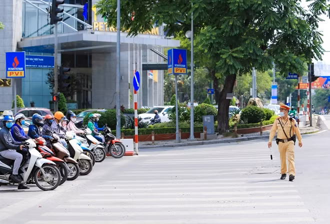 Tuy nhiên, mặc dù thời tiết nắng nóng oi bức là vậy, các chiến sĩ CSGT Hà Nội vẫn túc trực nhiều giờ liền theo ca kịp tại tất cả mọi nút giao thông hay điểm nóng về giao thông của Thủ đô để làm nhiệm vụ. Trong hình là chiến sĩ CSGT thuộc Đội CSGT số 3 làm nhiệm vụ tại nút giao thông Láng Hạ - Huỳnh Thúc Kháng trong ánh nắng chói chang.