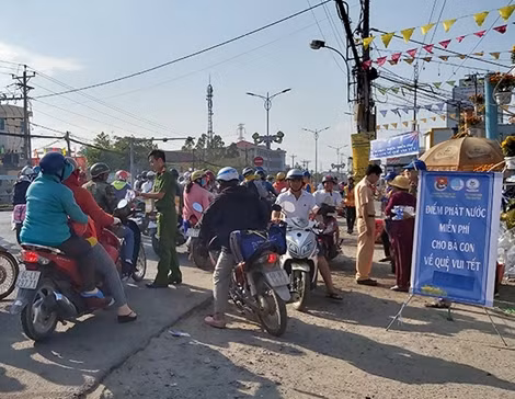 Công an Tiền Giang phát nước suối cho bà con về quê vui tết