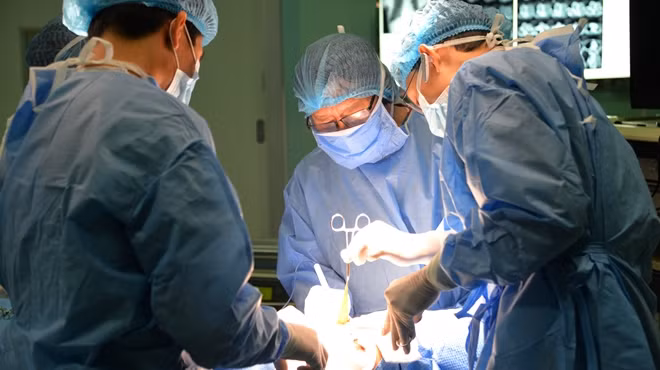 Các bác sĩ đang phẫu thuật, cắt bỏ khối u bướu khổng lồ
