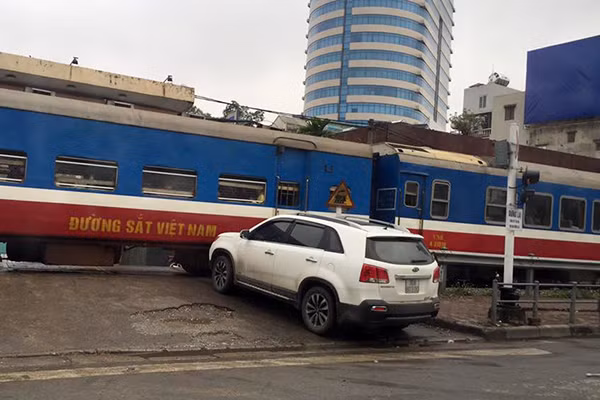 Xe ô tô suýt phải trả giá cho việc cắt mặt tàu hỏa. Ảnh: B.C.