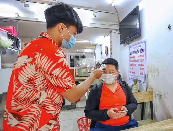 Khách hàng khi vào quán sẽ được đo thân nhiệt.