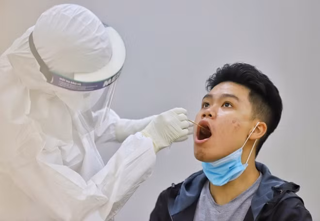 Nhân viên y tế lấy mẫu xét nghiệm COVID-19 dịch hầu họng.