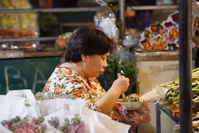 Bữa ăn đêm vội vã của một tiểu thương ngay trong chợ hoa Quảng An.