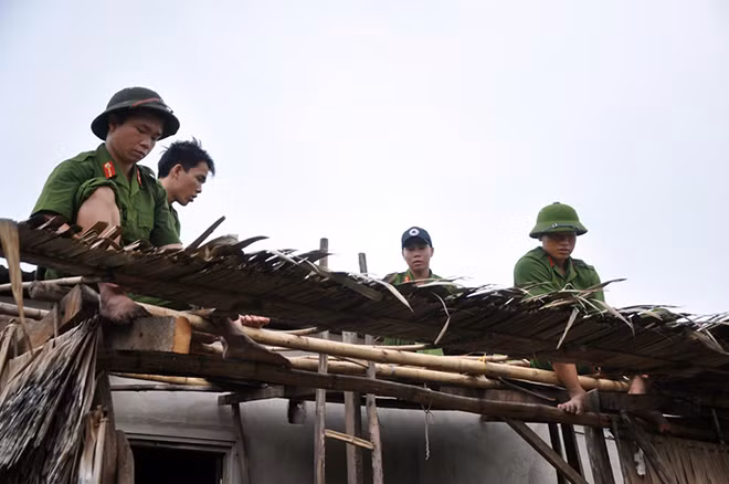 Các chiến sỹ Cảnh sát cơ động lợp mái nhà giúp dân. Các chiến sỹ Cảnh sát cơ động lợp mái nhà giúp dân.
