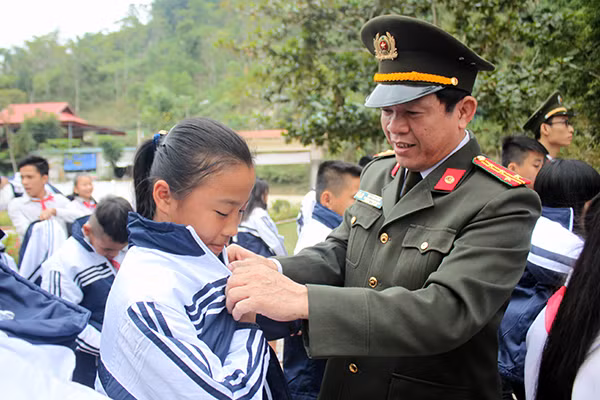 Lãnh đạo Công an tỉnh và lãnh đạo Phòng tổ chức cán bộ Công an tỉnh Nghệ An tặng áo cho các em.