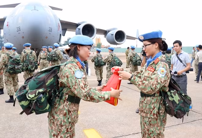 Các nữ quân nhân gấp quốc kỳ chuẩn bị lên đường nhận nhiệm vụ. (Ảnh: Xuân Khu/TTXVN)