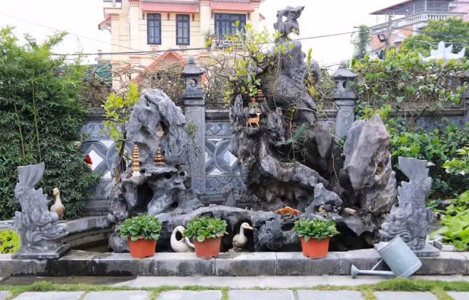 Trước sân nhà đặt hòn non bộ, hai con chó đá, cá chép hóa rồng… tạo thêm không gian cổ kính cho ngôi nhà.