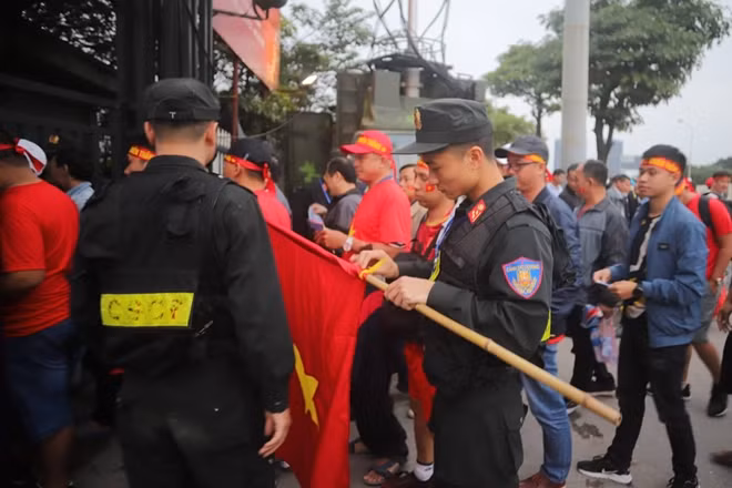 Cảnh sát cơ động kiểm tra từng lá cờ một để đảm bảo không có bất cứ vật dụng nguy hiểm nào lọt vào sân.