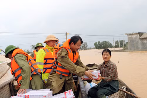 Đại tá Nguyễn Tiến Nam-Giám đốc Công an tỉnh Quảng Bình cùng cán bộ, chiến sỹ chèo đò vượt lũ đưa lương thực đến cho bà con.