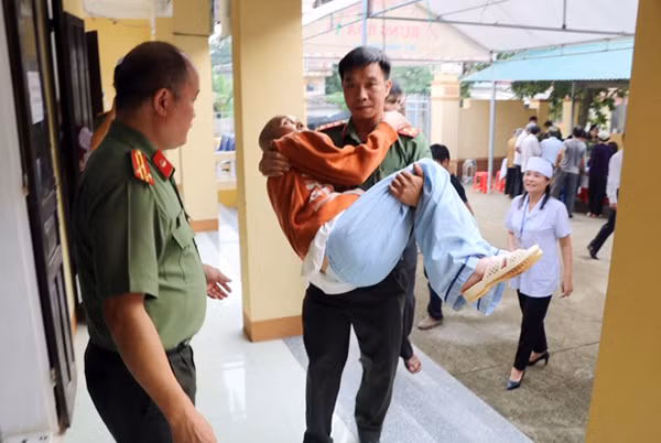 Hình ảnh đẹp trong buổi khám bệnh và cấp phát thuốc miễn phí khi một cụ ông cao tuổi được CBCS của đoàn công tác bế đưa vào khám bệnh.
